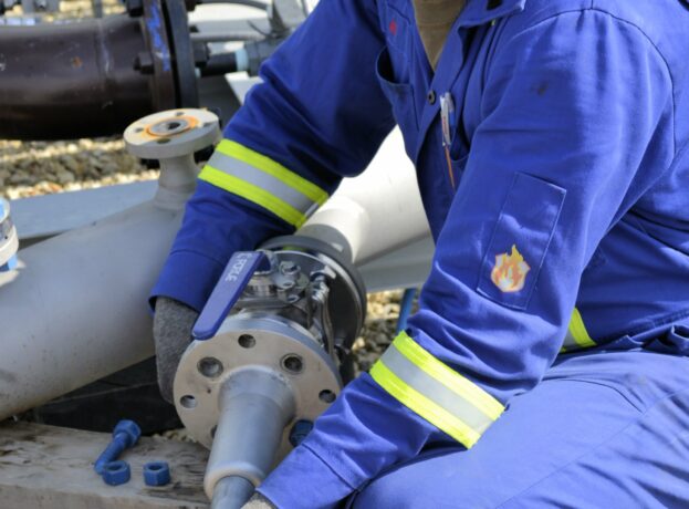 Service Engineer install an ultrasonic transducer on a pipeline