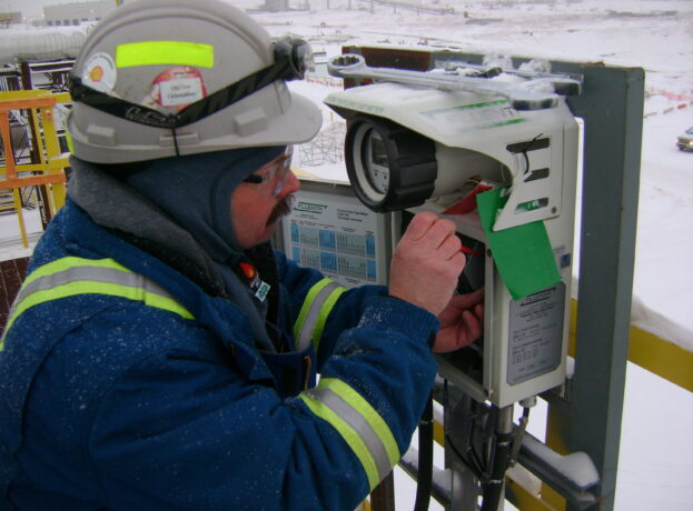 Service engineer performs maintenance on the FGM 160 ultrasonic field computer in extreme conditions